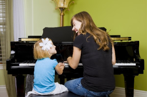 woman playing piano with girl